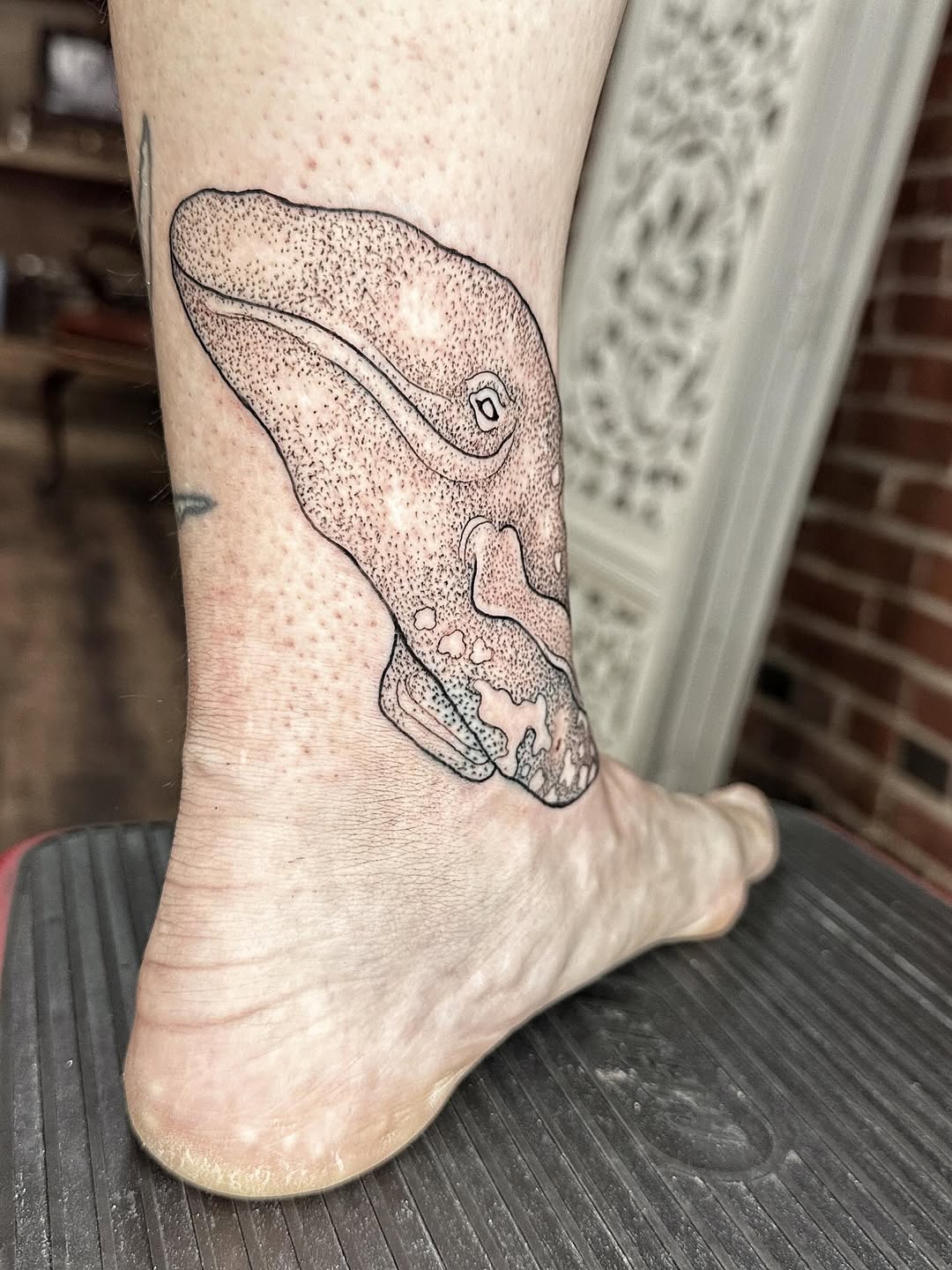 Freehand whale head silhouette with delicate dotwork shading