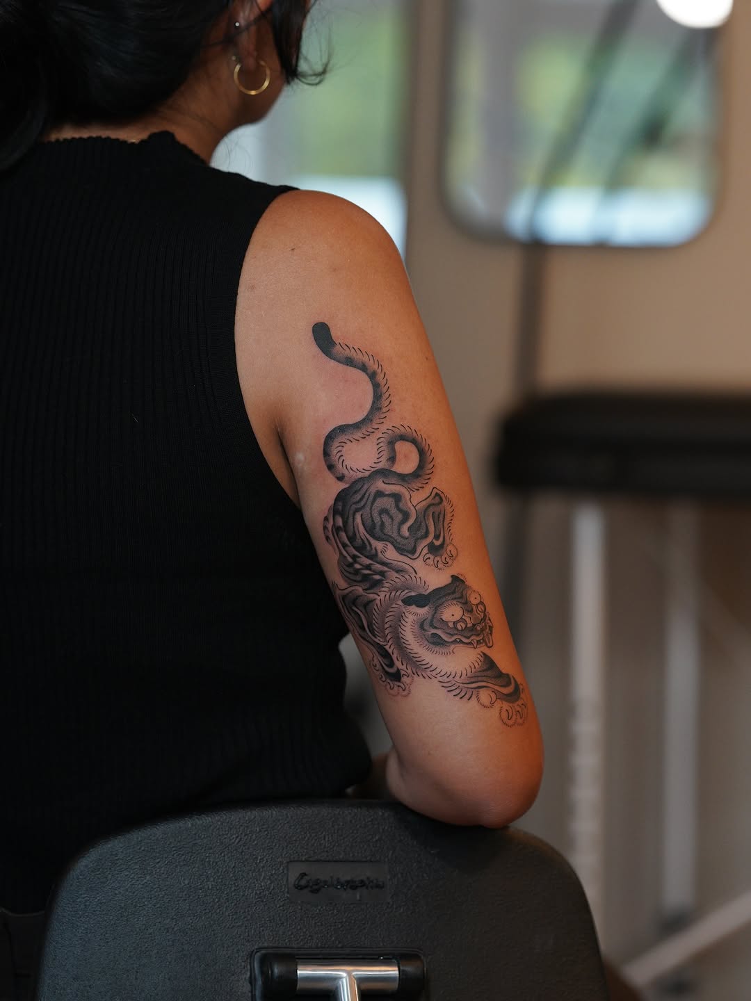 Bold blackwork tiger wrap-around arm with flowing lines