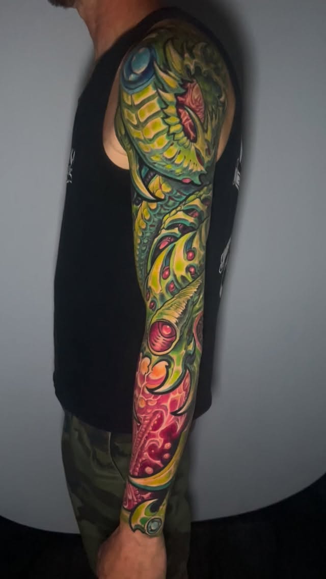 Vibrant biomechanical sleeve with neon greens and pinks.