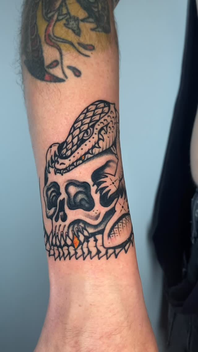 Bold skull with coiled snake, stark blackline shading.