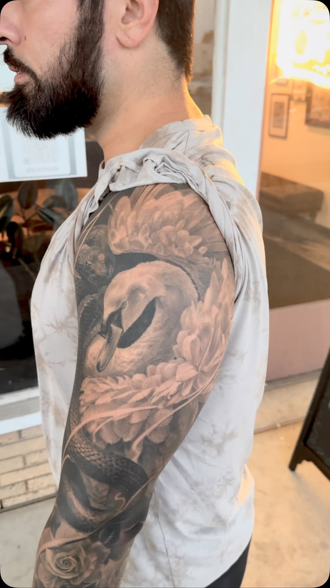 Ethereal grayscale swan surrounded by blooming peonies.