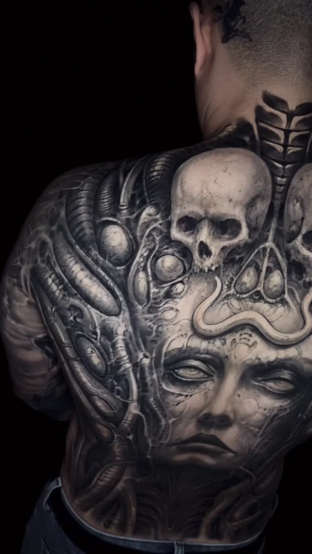 Grim biomechanical backpiece with skull motif and sinewy tubes