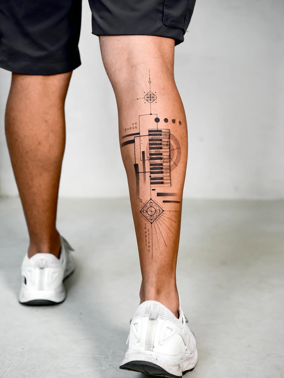 Geometric linework calf tattoo featuring piano-key motif