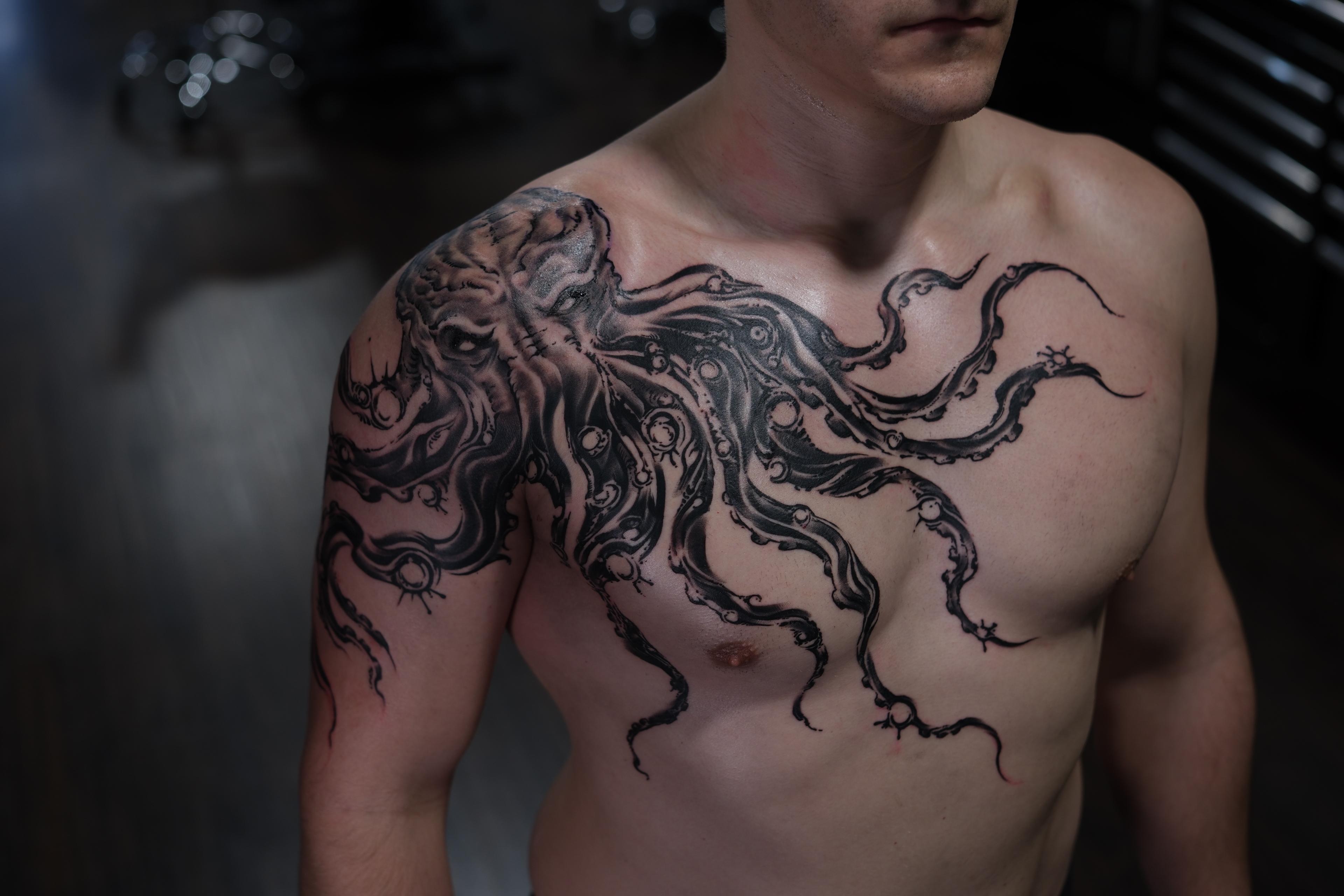 Monstrous blackwork octopus spanning shoulder to chest with tentacles.