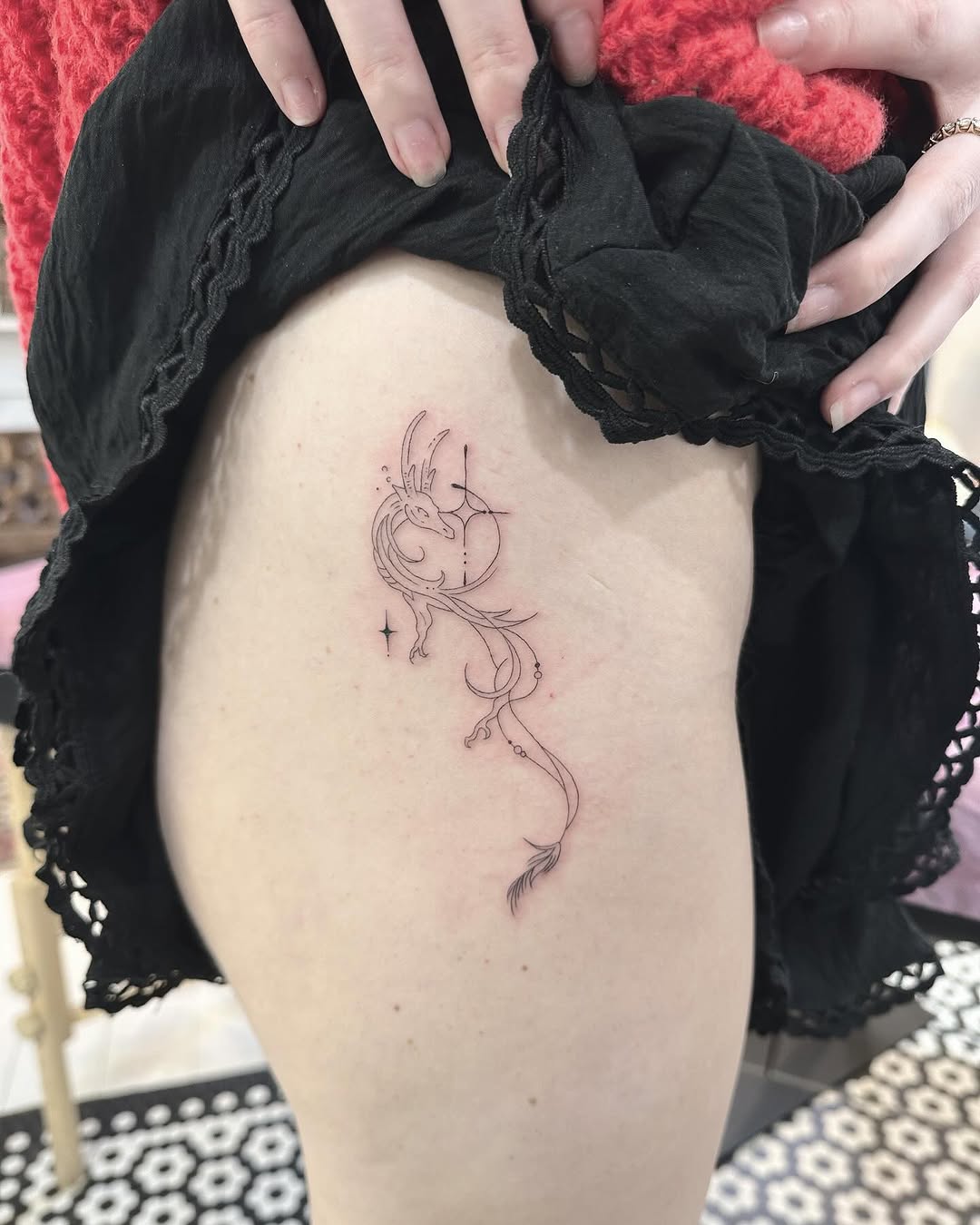 Delicate fineline dragon with curling tail and stars