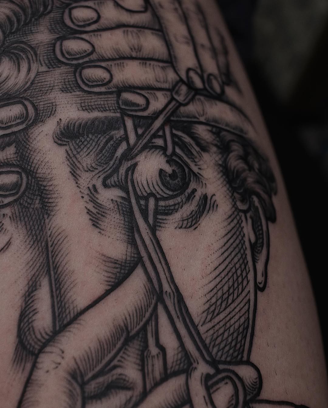 Engraving-style blackwork with an eye and surgical tools.