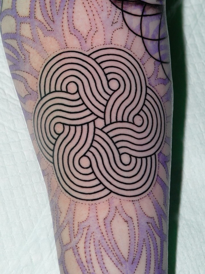Bold black-line geometric knot on forearm, striking