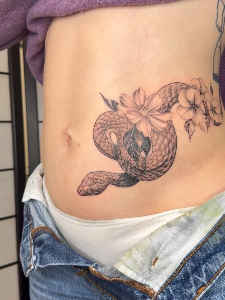 Elegant black-and-gray coiled snake with delicate blossoms