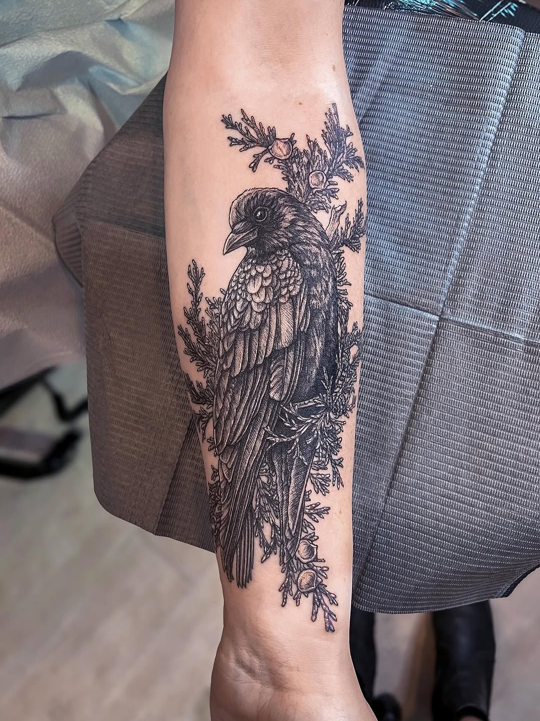 Intricate blackwork crow portrait with delicate botanical accents