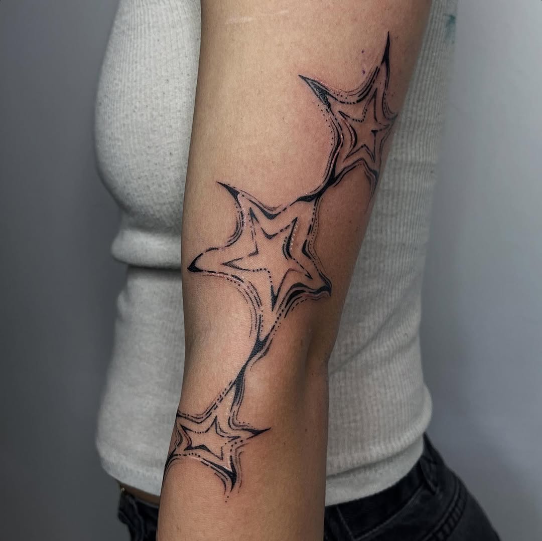 Delicate star-shaped linework across forearm with dotted accents