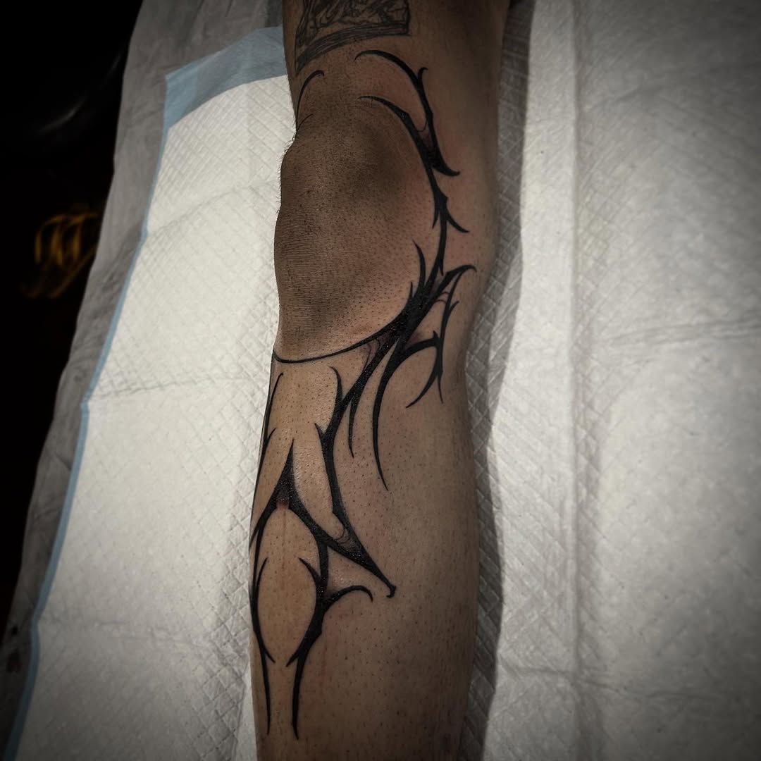 Sleek neo-tribal forearm tattoo with bold jagged lines