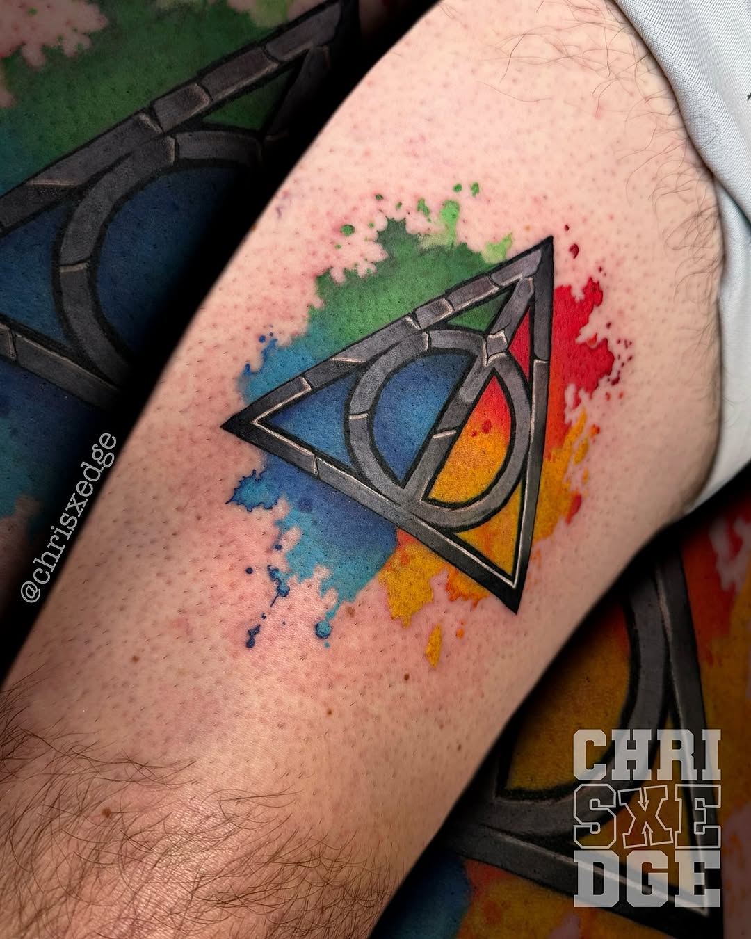 Bold geometric Deathly Hallows with rainbow watercolor backdrop