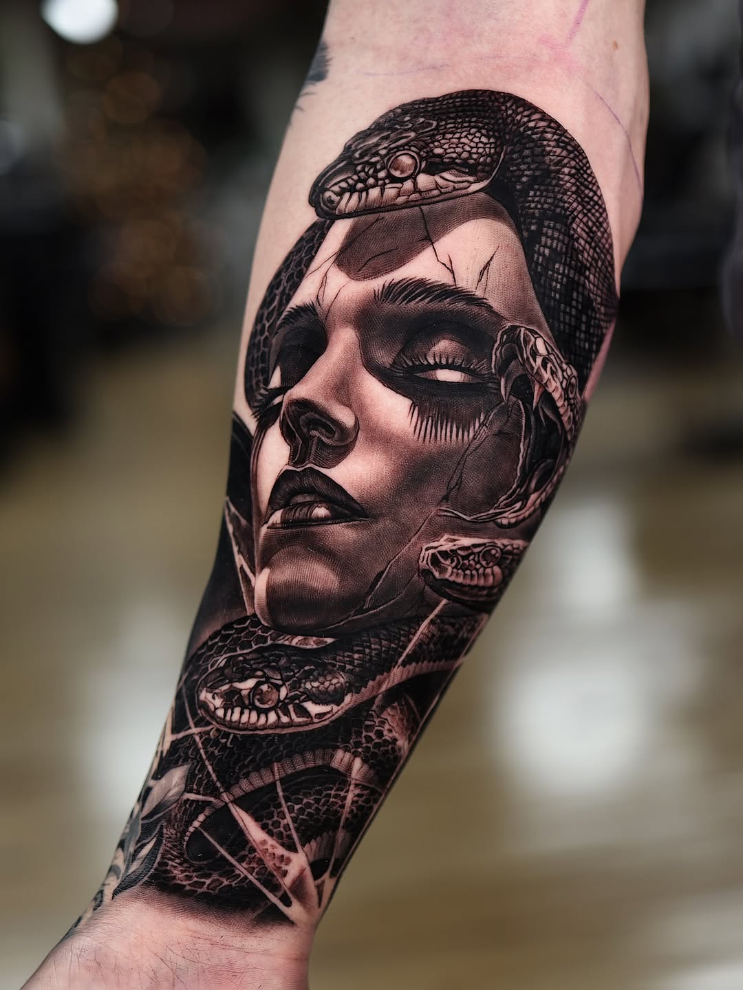Hyper-detailed black-and-gray Medusa with coiling snakes.