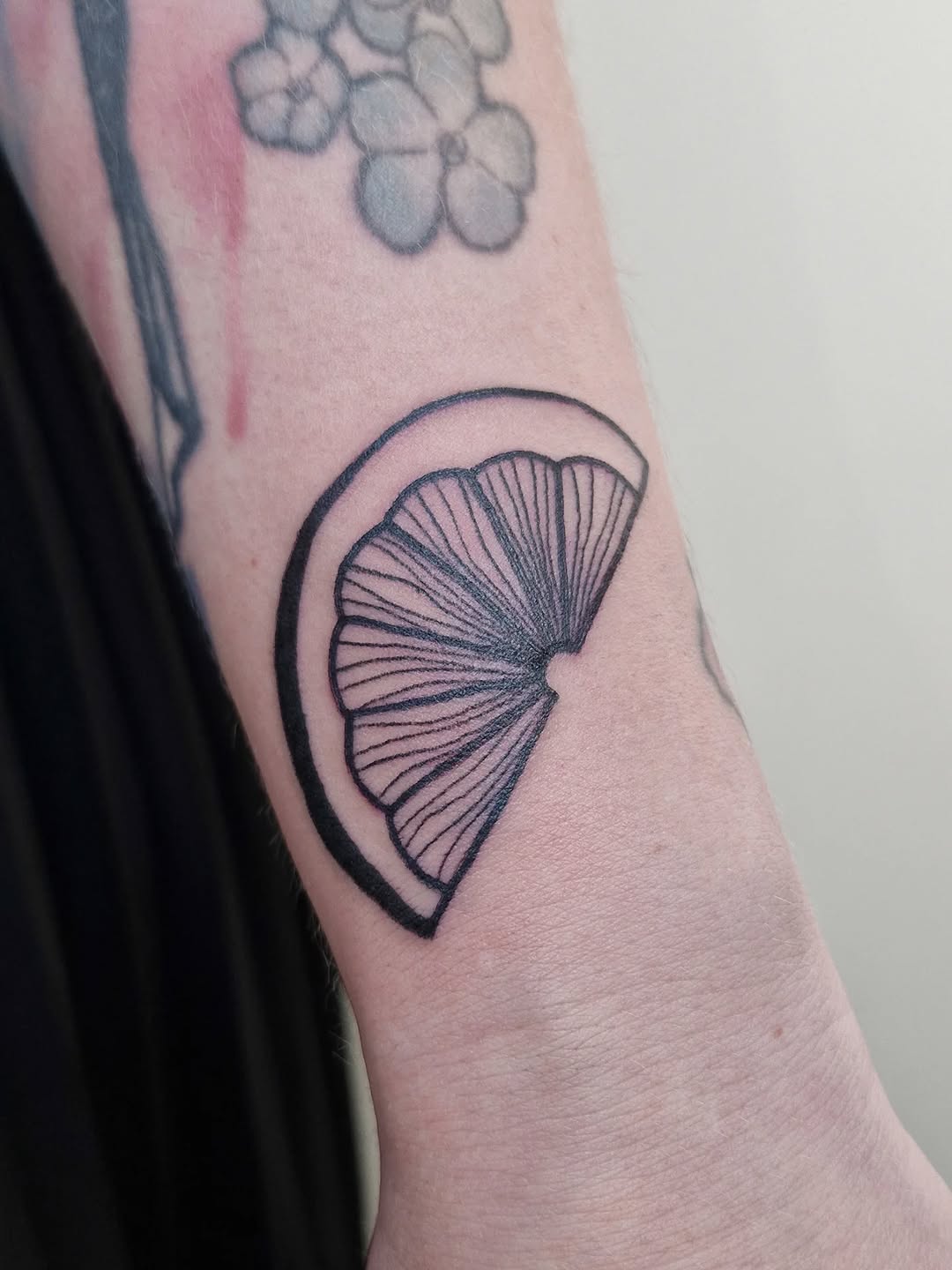 Minimalist black lemon slice within a circular frame.