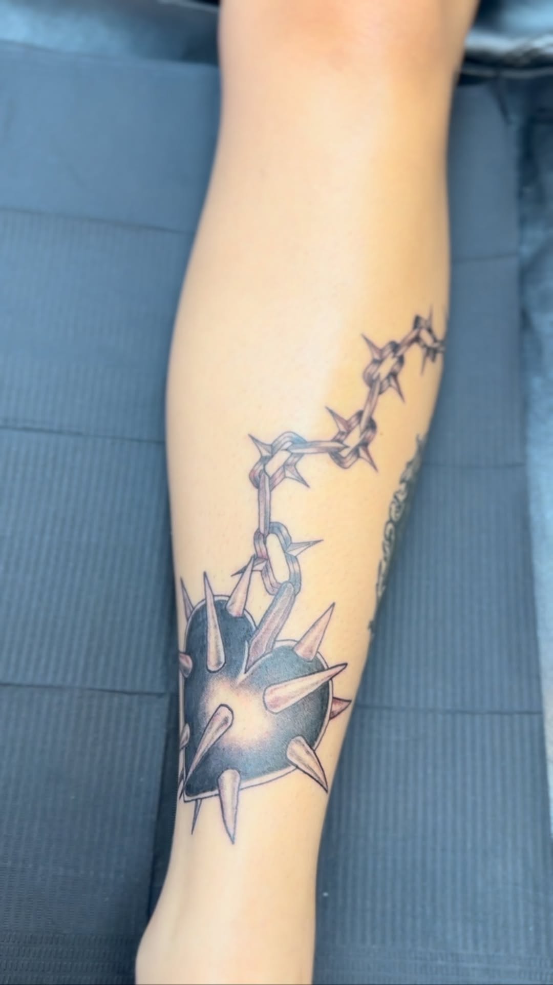 Bold spiked-ball chain wrap circling the calf