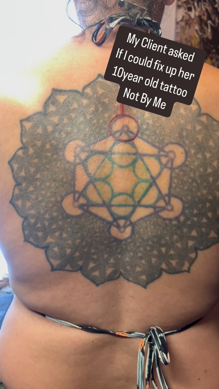 Intricate blackwork sacred-geometry mandala on upper back.
