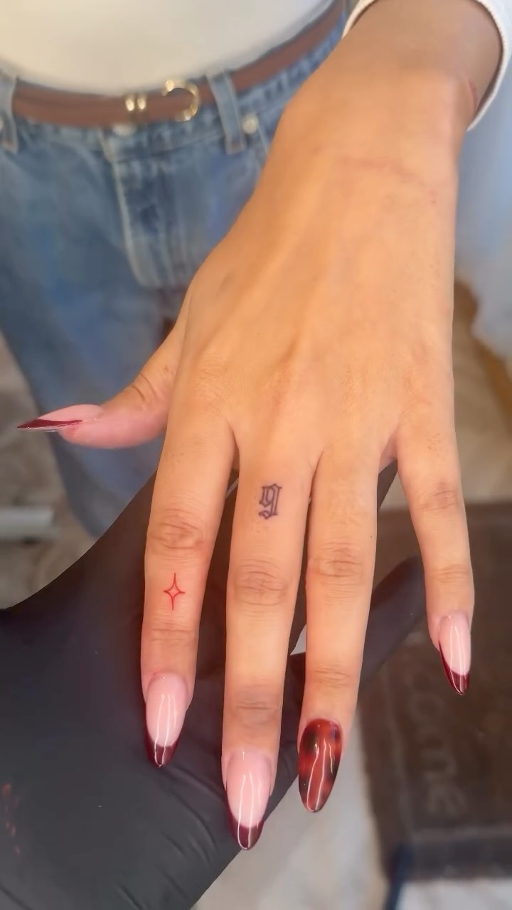 Minimalist finger tattoos: black gothic glyph, red star