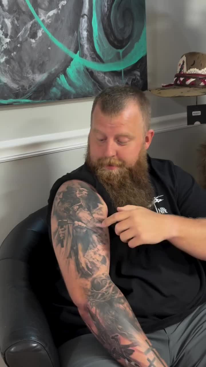 Dense grayscale arm sleeve with moody, figurative imagery and texture.