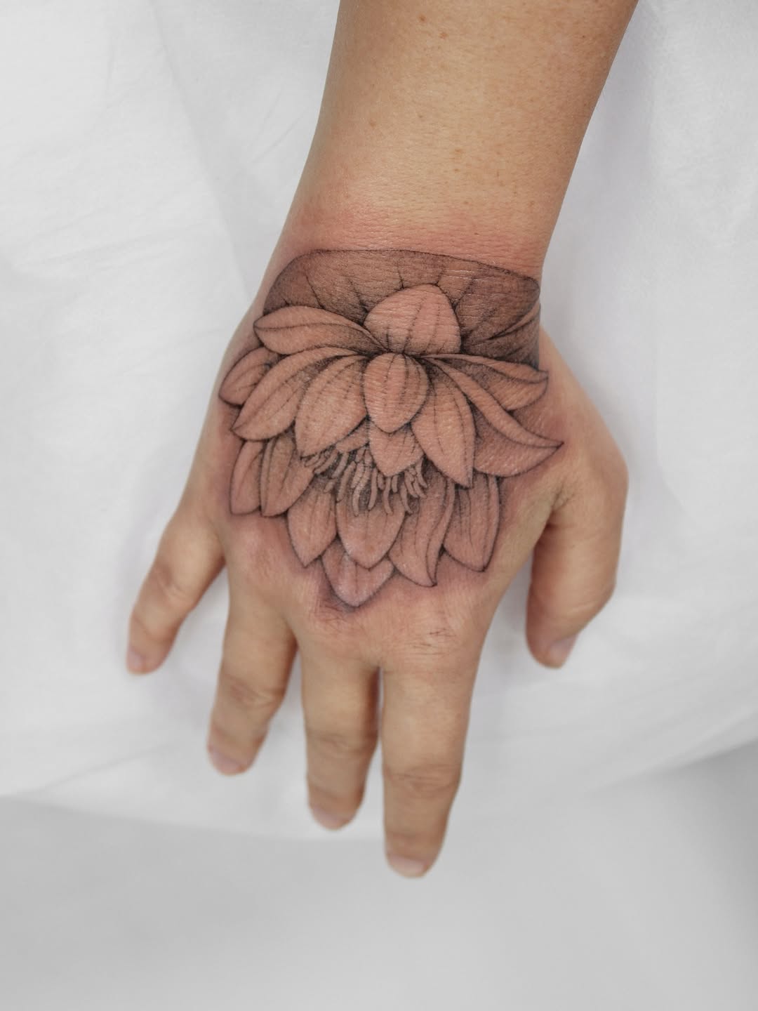 Delicate lotus on the hand with a bold wrist cuff