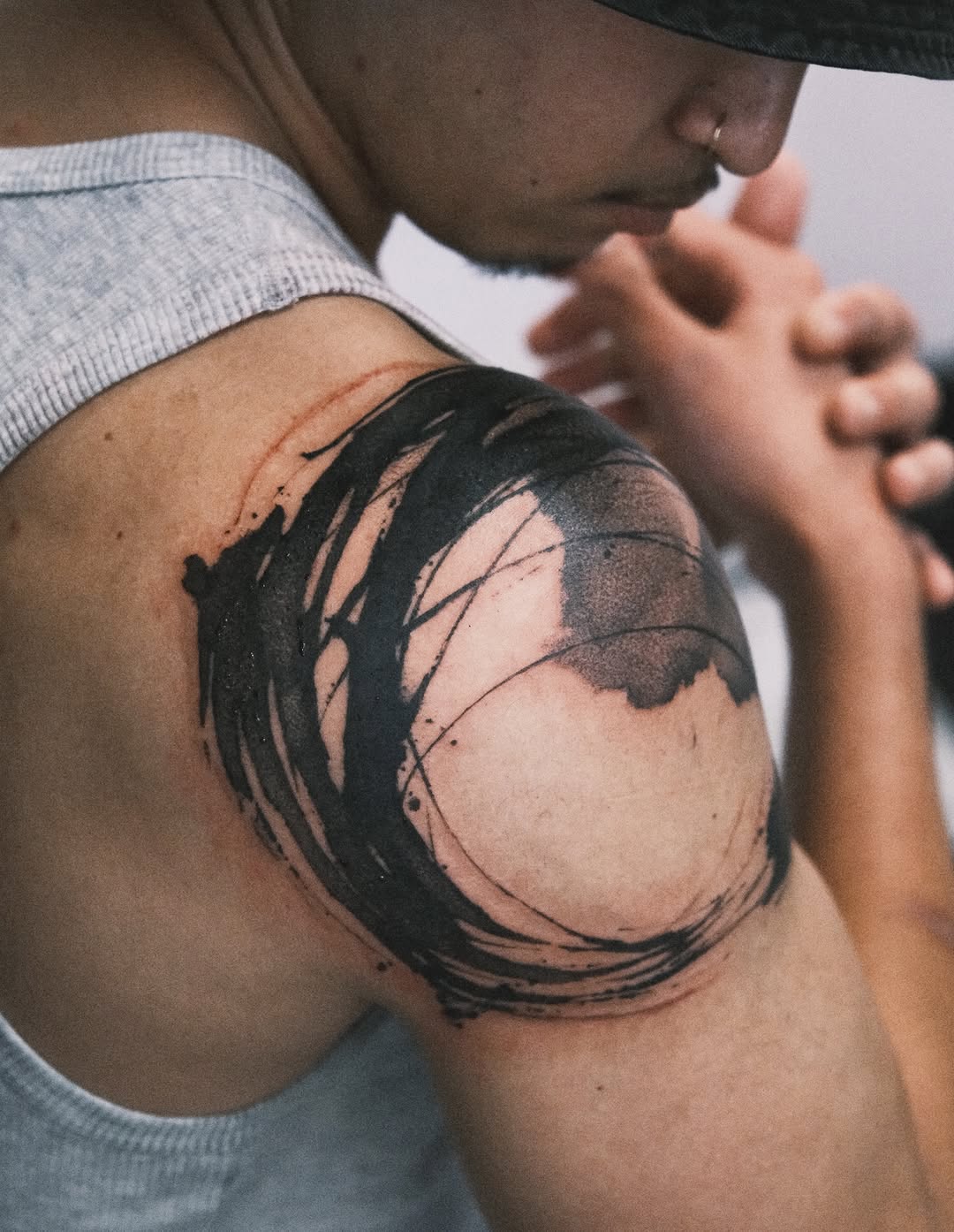 Bold enso brushstroke circle wraps the shoulder