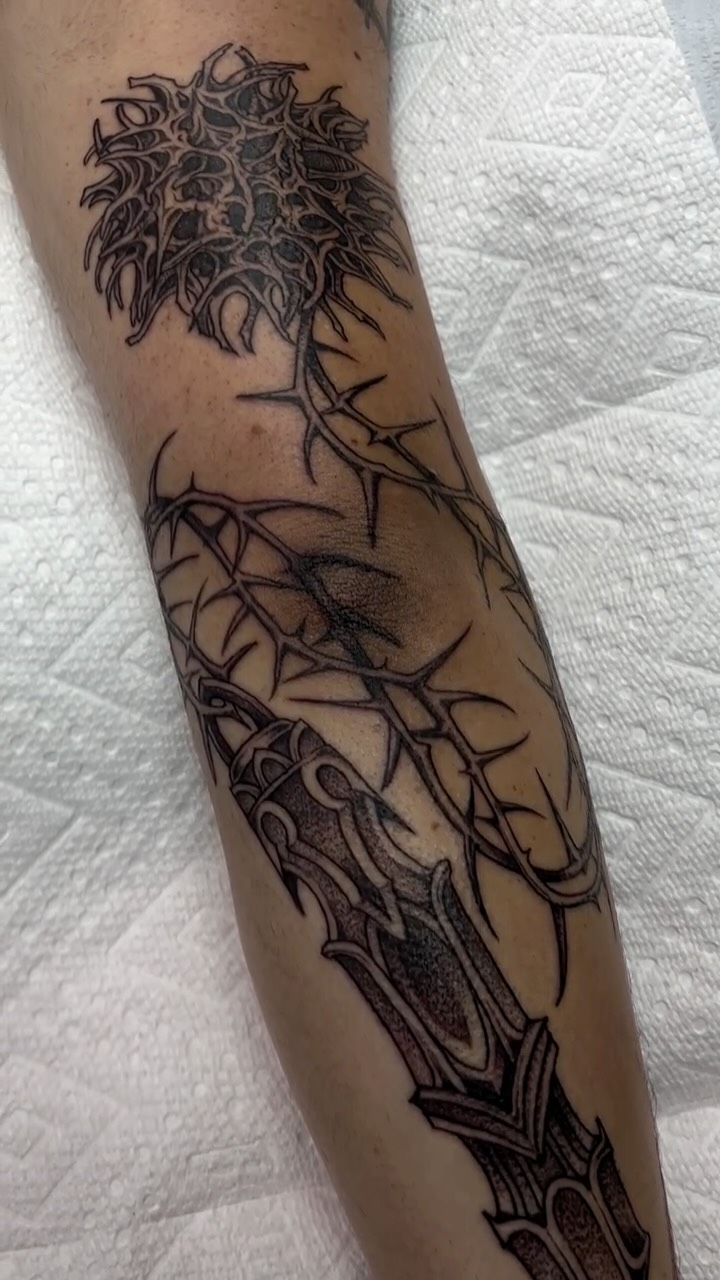 Intricate blackwork flail-inspired forearm piece with thorns
