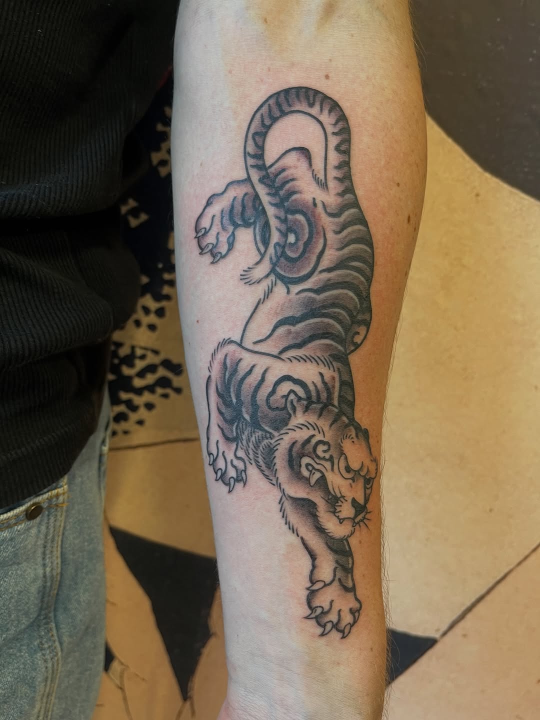 Bold blackline tiger on forearm, dynamic and fierce.