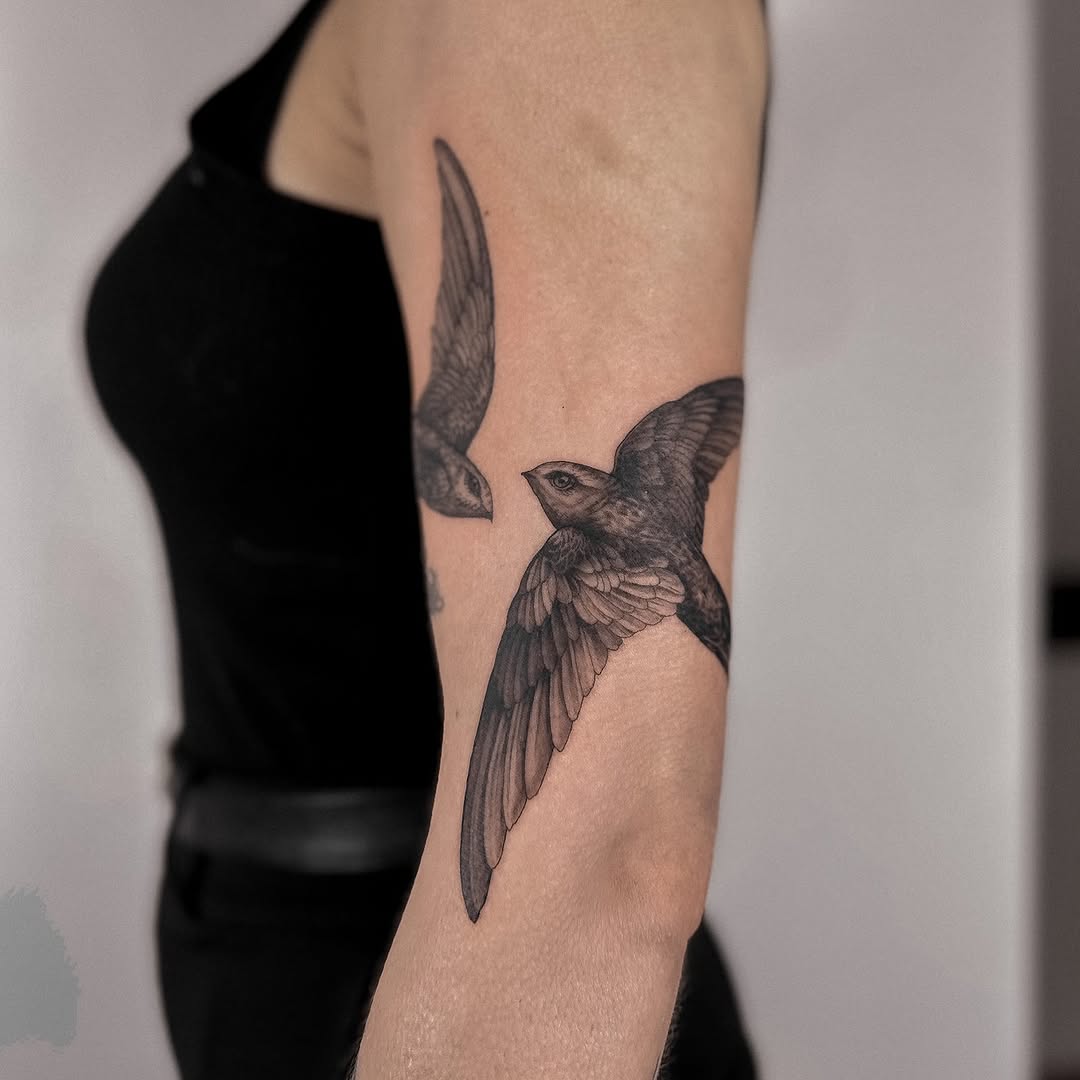 Delicate blackwork swift in flight with fine-line shading