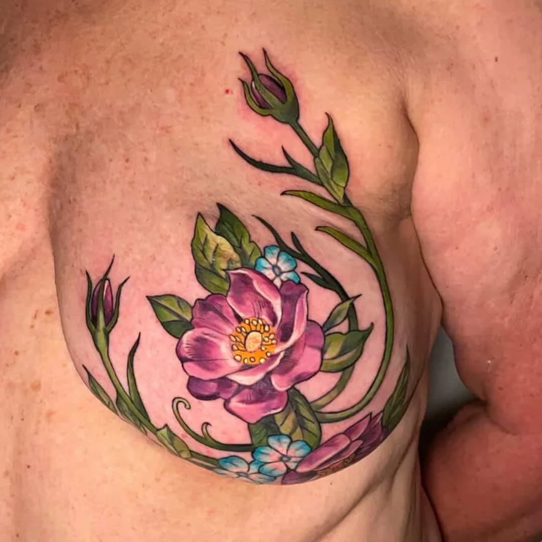 Vibrant floral tattoo with purple petals and blue blossoms wrapping chest.