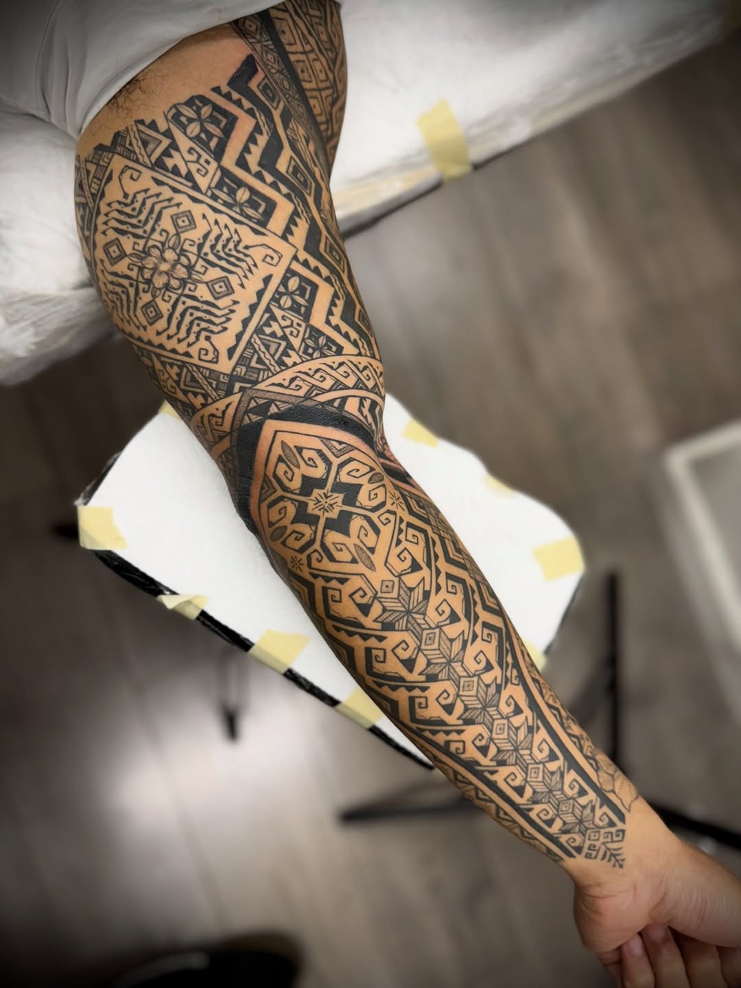 Intricate blackwork forearm sleeve with geometric tribal patterns