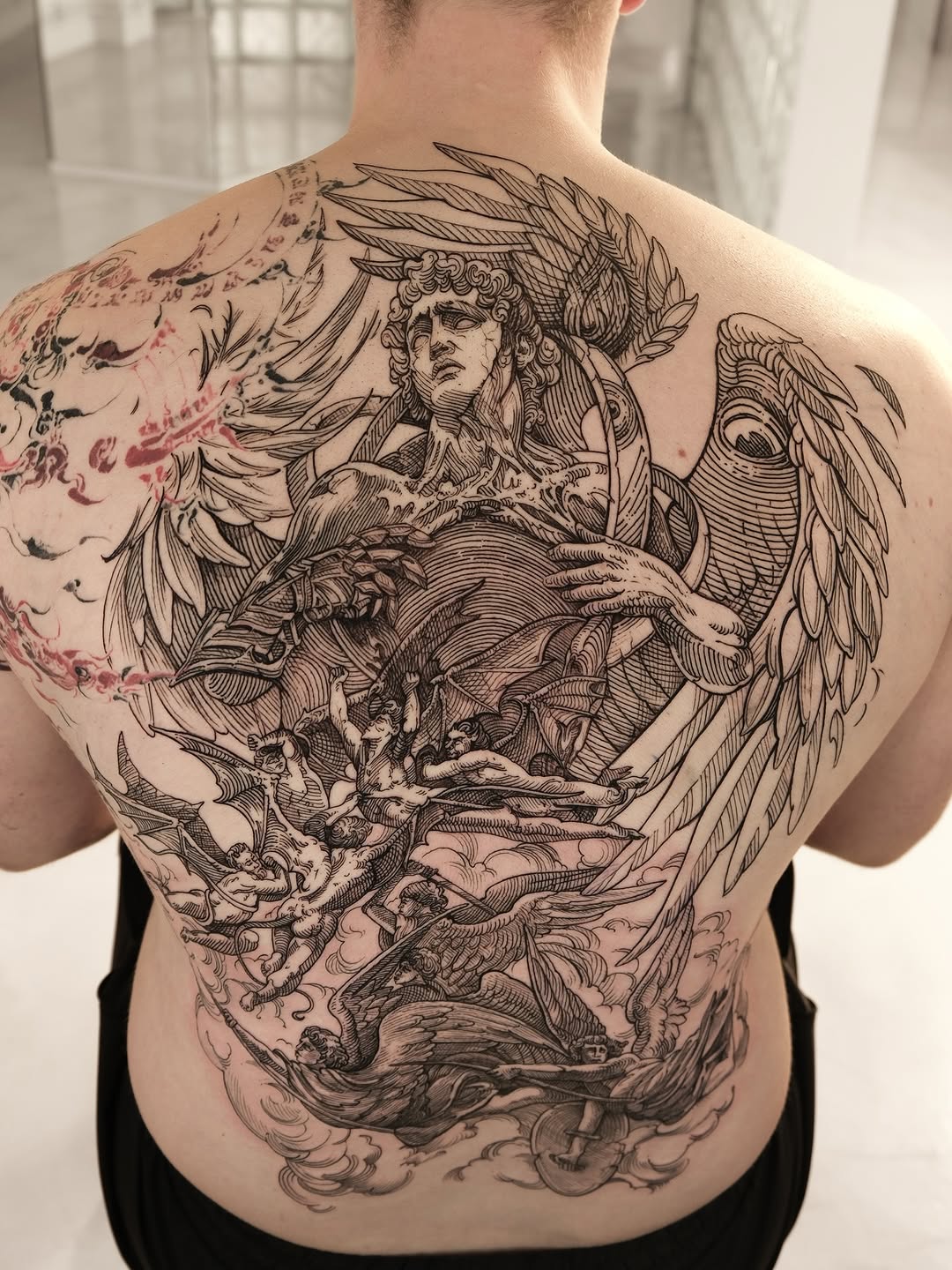 Intricate engraving-style back piece featuring an angelic figure with cherubs