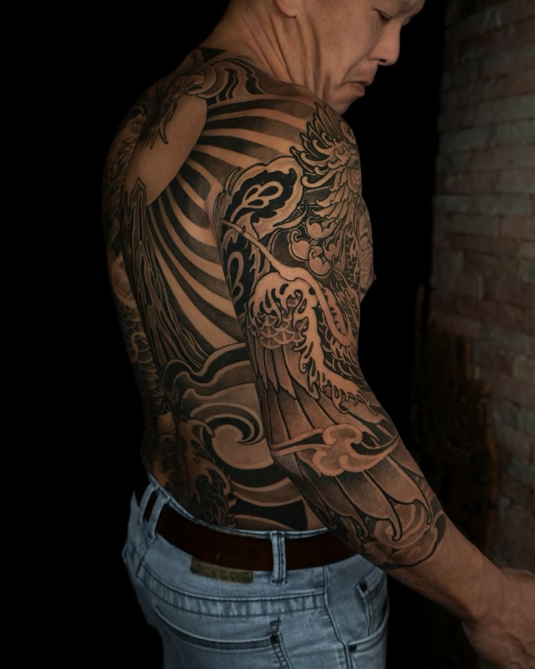 Bold blackwork dragon entwined with swirling ocean waves