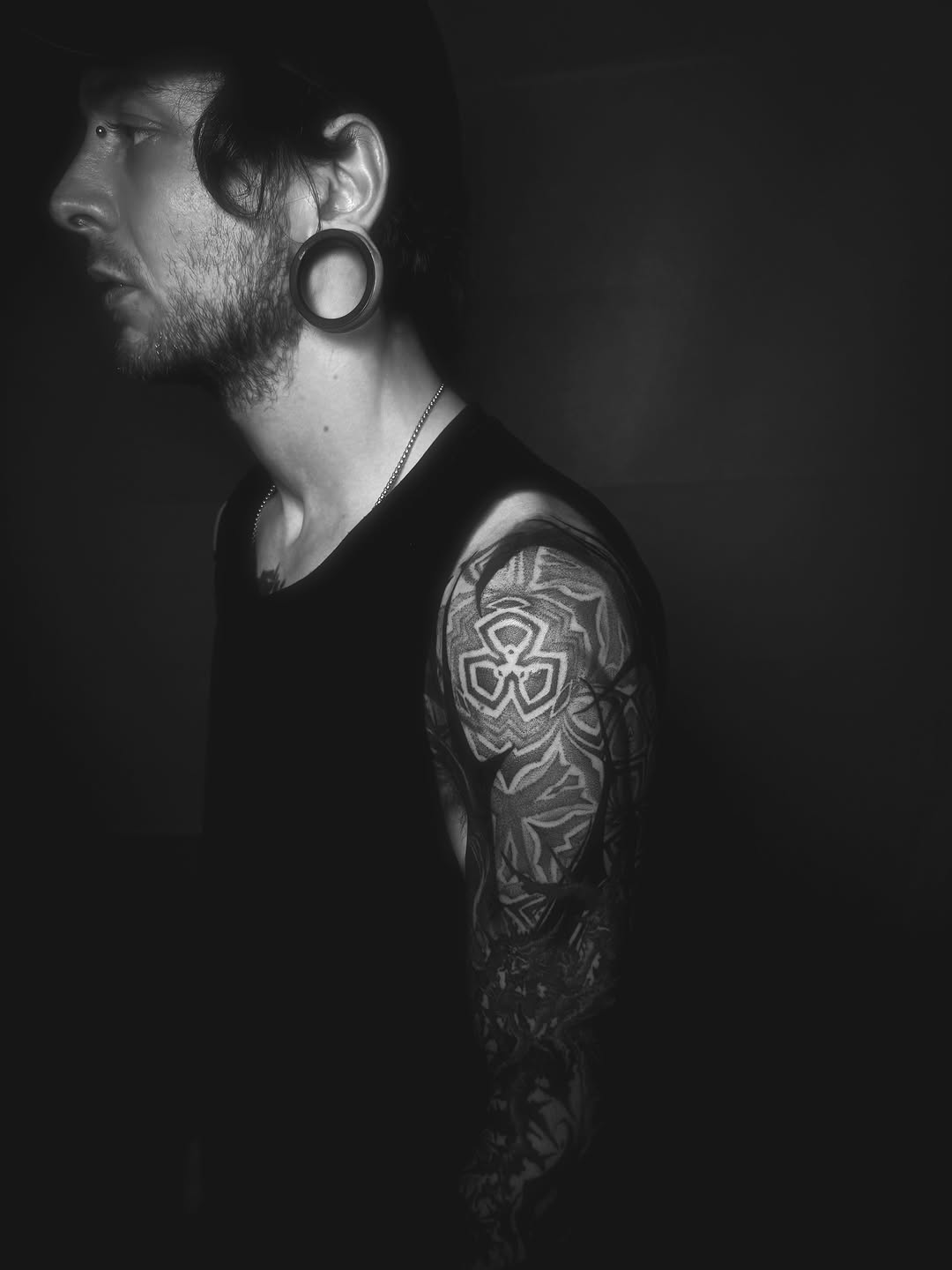 Monochrome geometric blackwork sleeve with interlocking shapes.