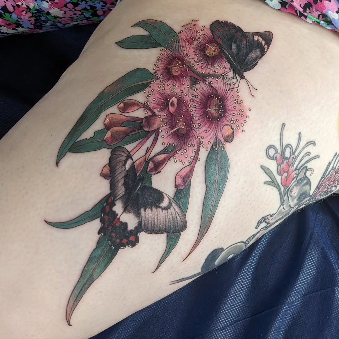 Vibrant orchid-swallowtail butterflies amid pink gum blossoms.