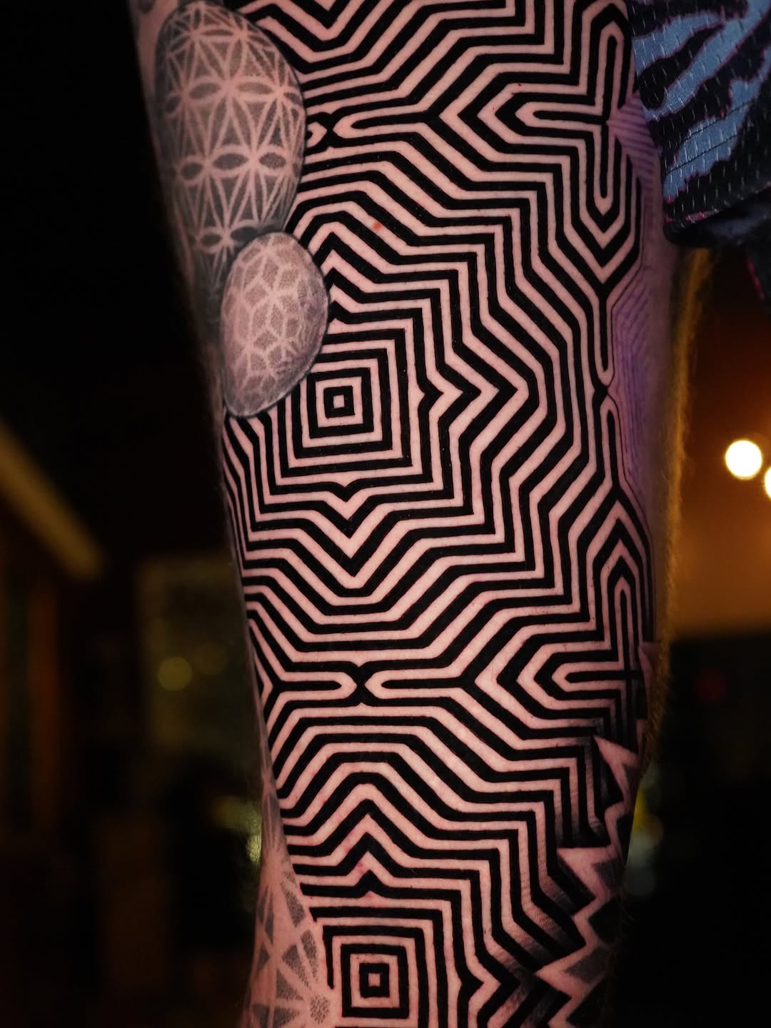 Hypnotic concentric maze lines wrap around the forearm