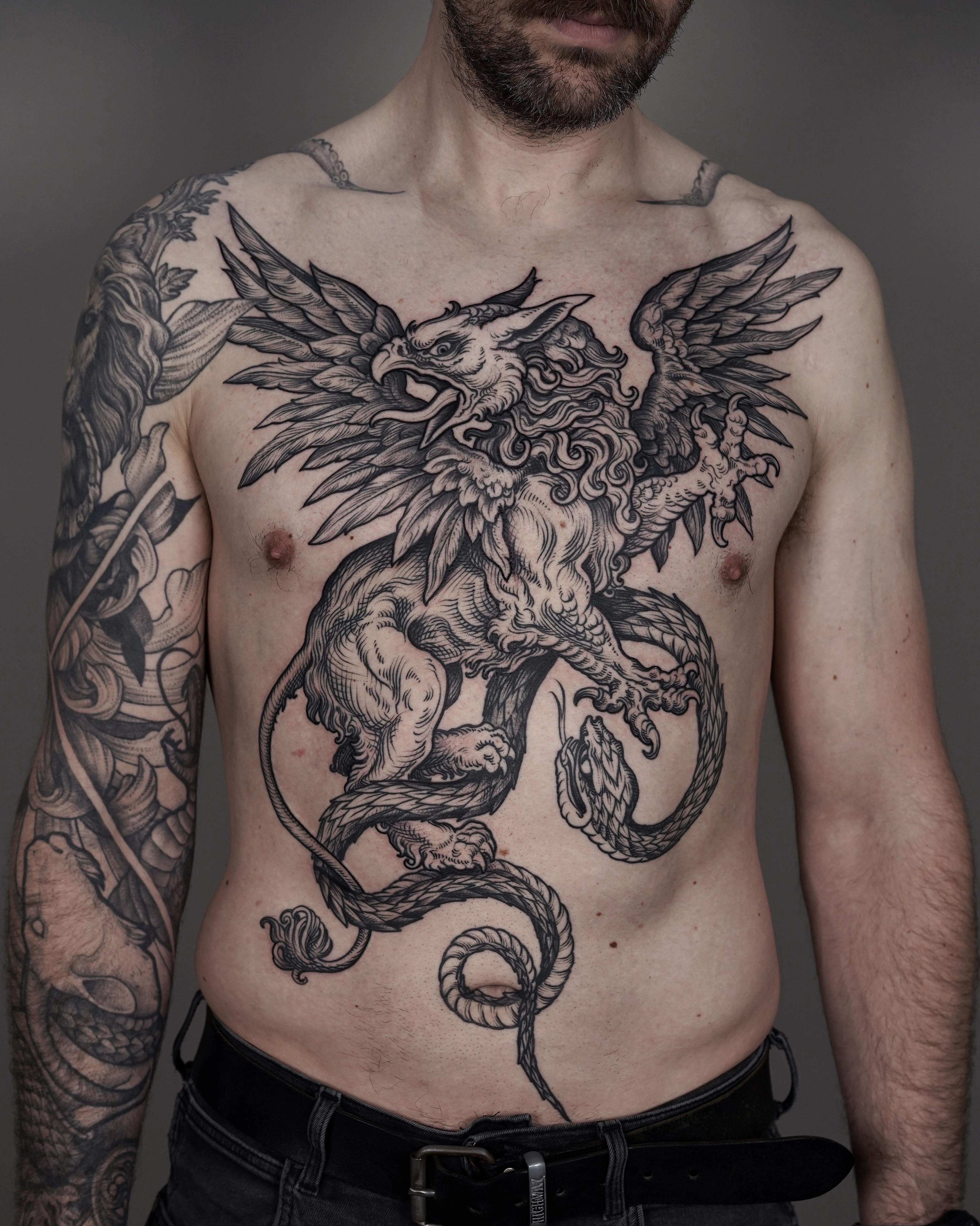 Epic blackwork griffin and snake clash across the chest