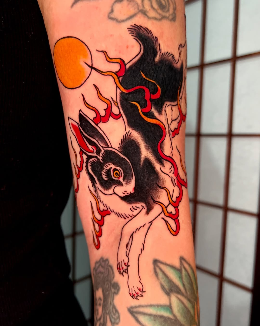 Bold neo-traditional rabbit leaping amid fiery ribbons