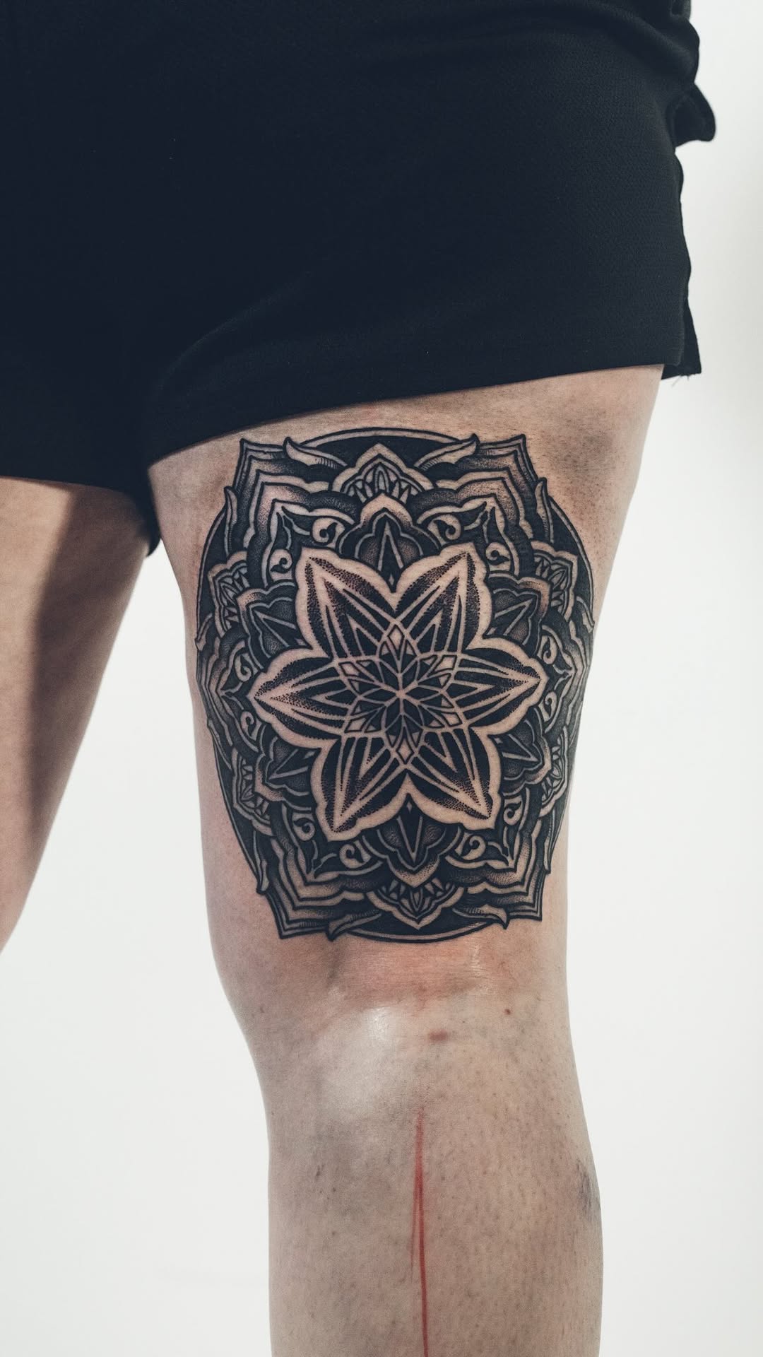 Bold blackwork mandala flower on outer thigh intricate linework