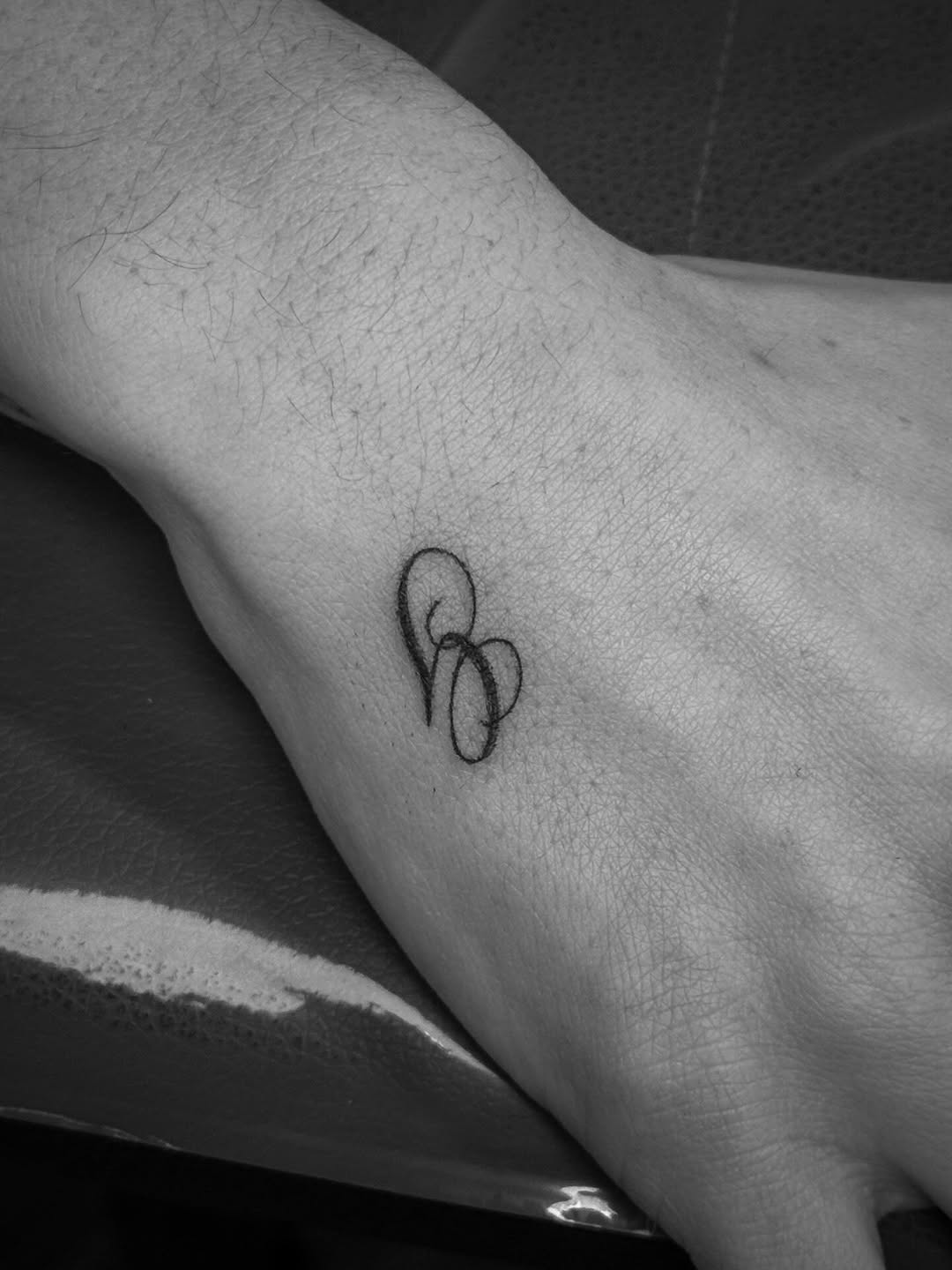 Minimalist looping knot tattoo in delicate fine-line style