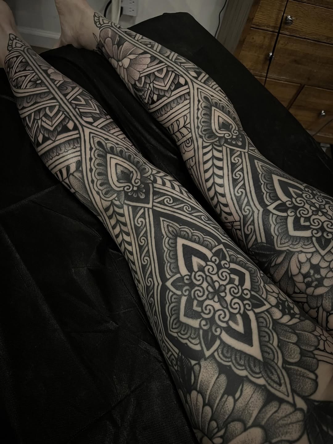 Ornamental blackwork mandala motifs spanning both calves