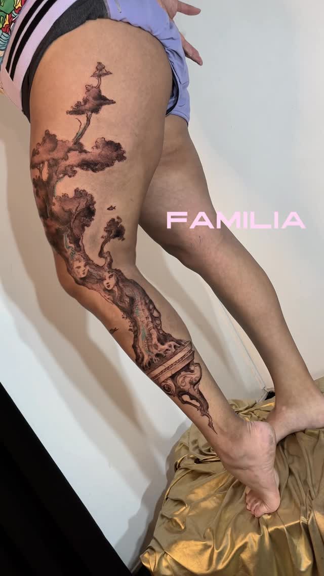 Intricate grayscale forest-tale leg piece with a female figure entwined in trees