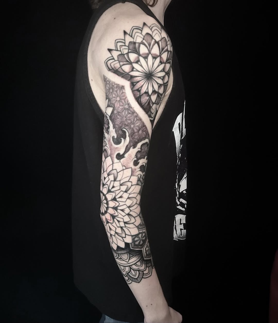Intricate blackwork sleeve with geometric mandalas and floral motifs