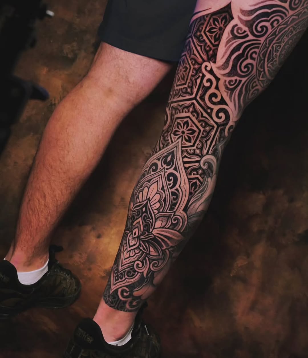 Intricate blackwork geometric leg sleeve with mandala motifs