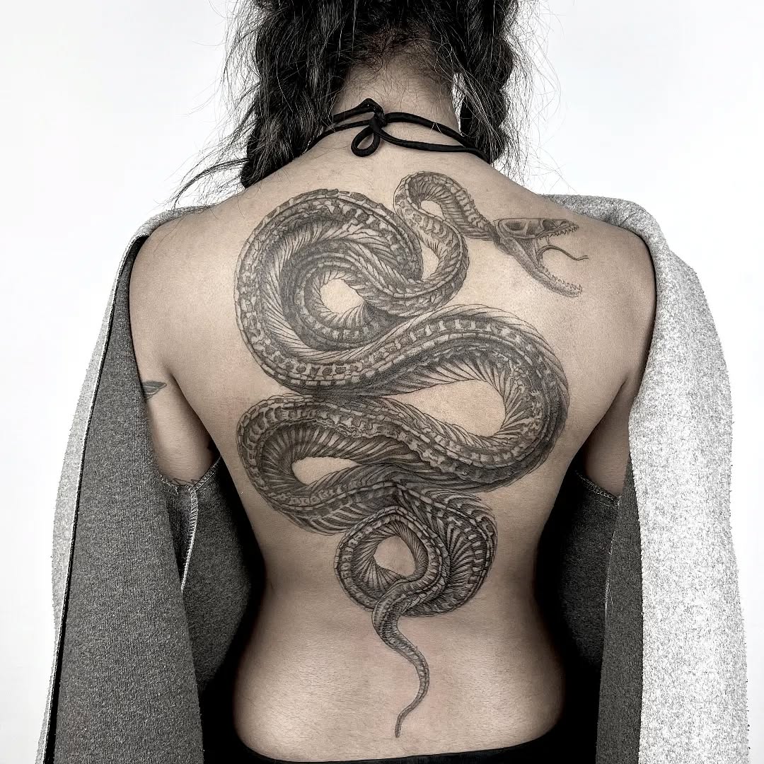 Coiled blackwork snakes weave across the back in detail.