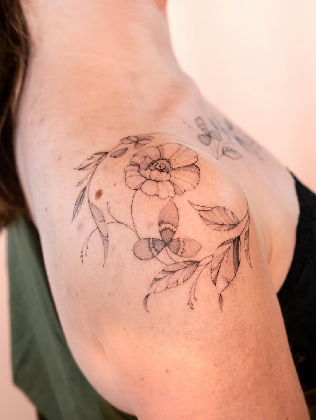 Delicate fine-line floral shoulder piece with curling vines.