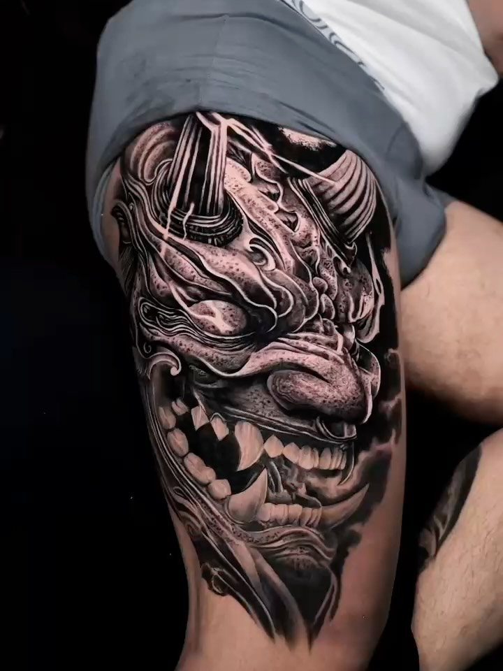 Intricate black-and-gray oni demon mask with ferocious fangs