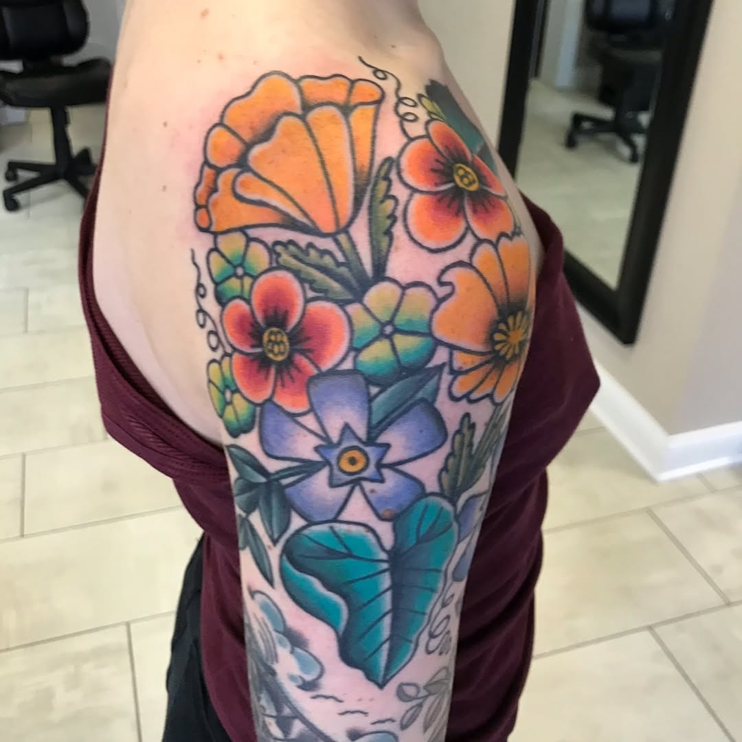 Vibrant neo-traditional floral sleeve with orange and blue blooms