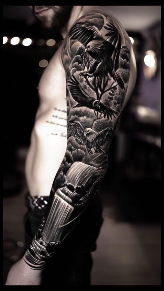 Dynamic black-and-gray eagle-filled sleeve with waterfall landscape