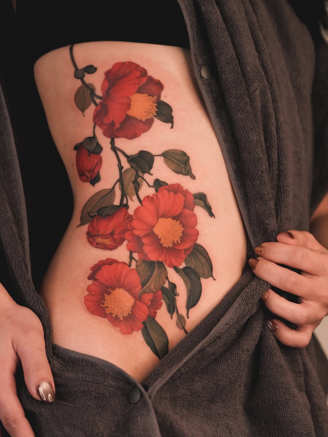 Vibrant red camellias cascade along a dark vine.