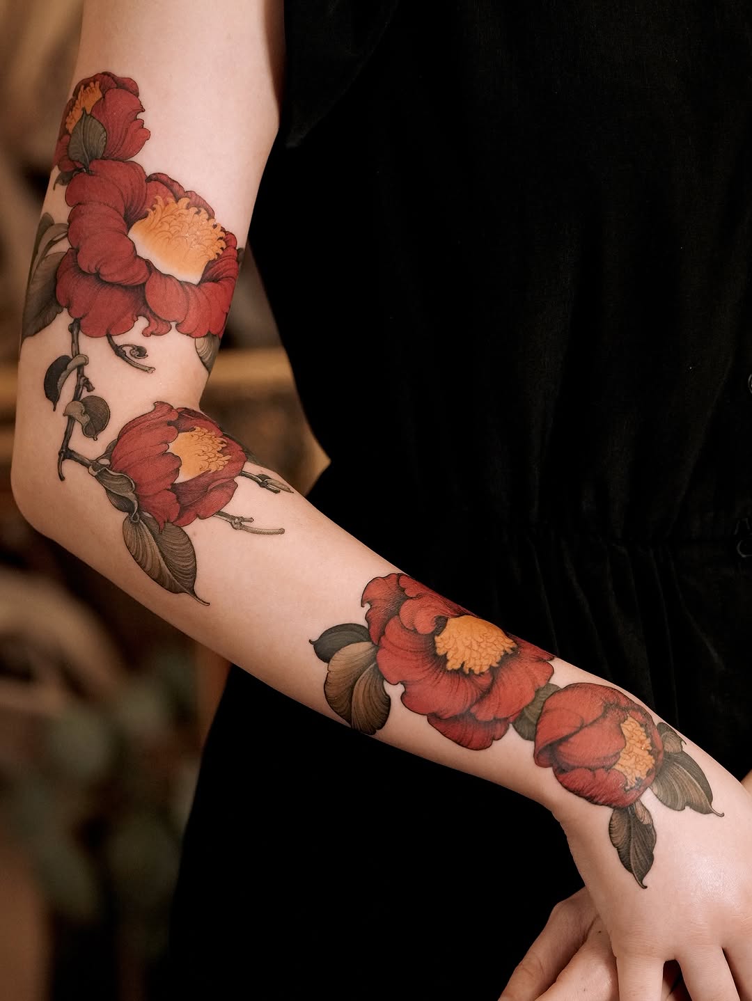 Vibrant red camellia sleeve with bold green leaves