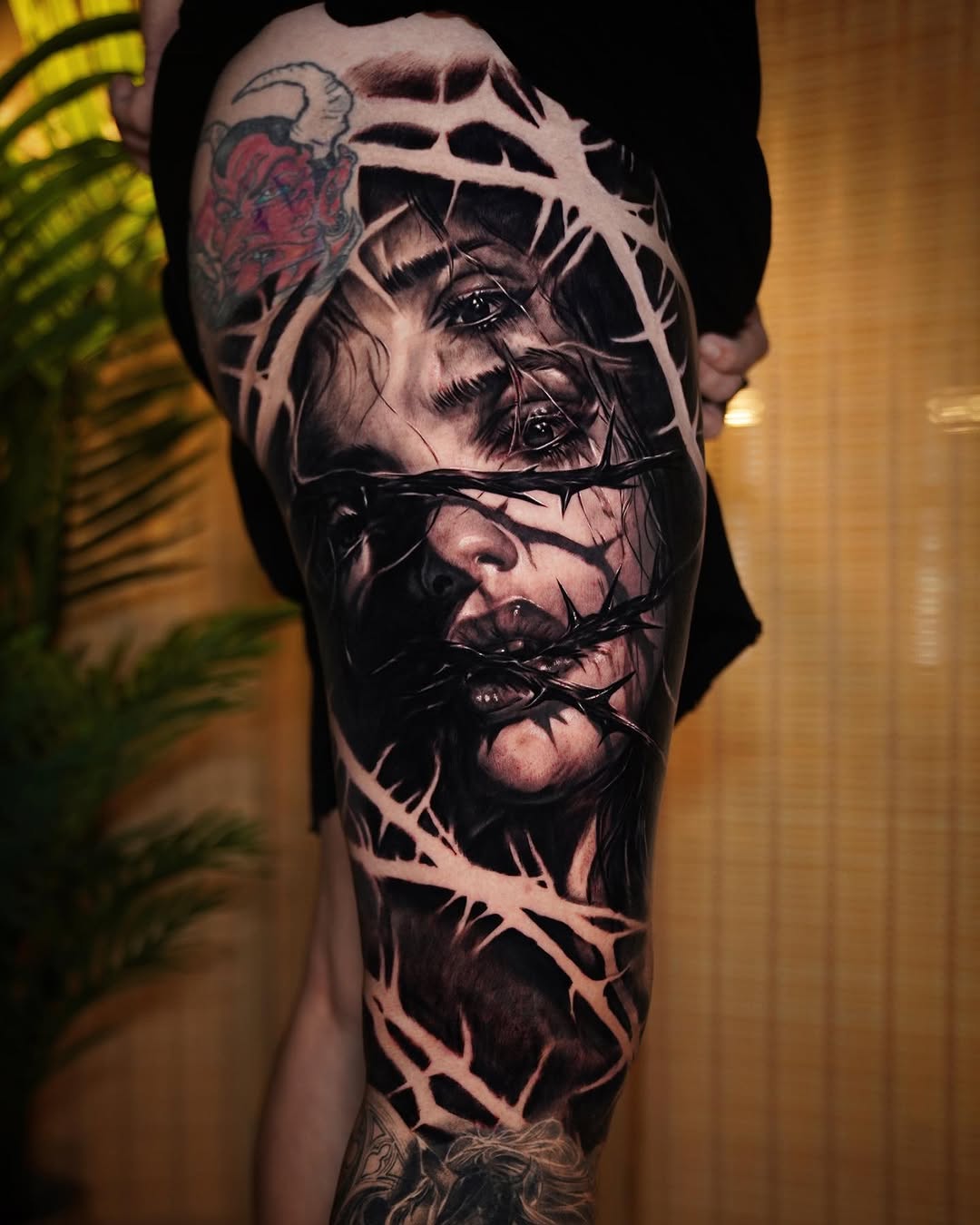 Hyper-realistic grayscale portrait interlaced with barbed wire